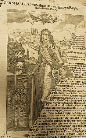 Die Seite der Bibel zeigt einen Mann. Er hat eine Rüstung an. Er trägt halblange Haare und einen Schnauzbart. Im Hintergrund sieht man einen Fluss und eine Burg.